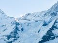 An aerial shot shows Verbier, Switzerland's snowy landscape, ski tracks, a peak