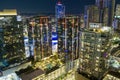 aerial shot of skyscrapers, hotels and office buildings in the city skyline at night with colorful lights and cars driving Royalty Free Stock Photo