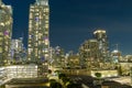 aerial shot of skyscrapers, hotels and office buildings in the city skyline at night with colorful lights and cars driving Royalty Free Stock Photo