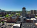 aerial shot of skyscrapers, office buildings, and apartments with lush green trees, mountains with cars on the street