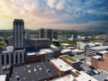 aerial shot of skyscrapers, office buildings, and apartments with lush green trees, mountains, cars on the street