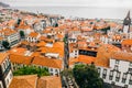 Aerial shot of small houses with orange rooftops by the Atlantic ocean in the Madeira island Royalty Free Stock Photo