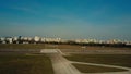 Aerial shot of a small propeller airplane landing on city airport runway on a sunny day Royalty Free Stock Photo