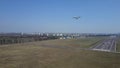 Aerial shot of a small propeller airplane taking off from city airport runway on a sunny day Royalty Free Stock Photo