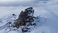 Aerial shot of the sphinx of Bucegi on a cold winter day, snow on the area of the rock