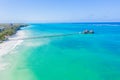 Aerial shot of the Stilt hut with palm thatch roof washed with turquoise Indian ocean waves on the white sand sandbank beach on Royalty Free Stock Photo