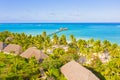 Aerial shot of the Stilt hut with palm thatch roof washed with turquoise Indian ocean waves on the white sand sandbank beach on