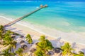 Aerial shot of the Stilt hut with palm thatch roof washed with turquoise Indian ocean waves on the white sand sandbank beach on