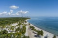 aerial shot of a stunning summer landscape at Crandon Park with blue ocean water, lush green palm trees and grass, a sandy beach