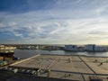 An aerial shot of a stunning sunrise over Mobile Bay with buildings, shipping cranes, ships docked and a gorgeous blue sky