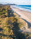 Aerial shot at sunrise over the ocean, sand beach with swimmers and surfers enjoying summer. Byron Bay, Tallow beach Royalty Free Stock Photo