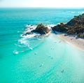 Aerial shot at sunrise over the ocean and white sand beach with swimmers and surfers enjoying summer Royalty Free Stock Photo