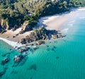 Aerial shot at sunrise over the ocean and white sand beach with swimmers and surfers enjoying summer Royalty Free Stock Photo