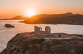 Aerial shot of the temple of Poseidon at a bright orange sunset in Athens, Greece