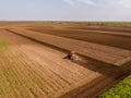 Aerial shot of a tractor cultivating field at spring Royalty Free Stock Photo
