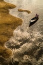 An aerial shot of a Vietnamese fisherwoman riding a wooden boat