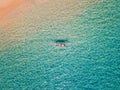 Aerial shot of woman relaxing in a kayak Summer seascape beach and blue sea water Top view from drone