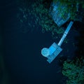 Aerial shot of a wooden landing stage in the middle of a dark lake