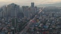Aerial slide and pan footage of traffic on wide multilane road in city at dawn. Cars driving on thoroughfare around