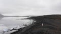 Aerial slow motion view tourist woman traveler walk by Fjallsjokull glacier in Iceland outdoors while travels