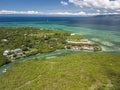 Aerial of a small channel in Dauis, Panglao Island. Undeveloped land and residential houses. A reef surrounds the island