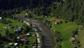 Aerial small mountain village among vivid green trees warm summer sunny day Royalty Free Stock Photo