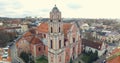 AERIAL. Smooth flight up beautiful Church of All Saints (Visu Sventuju) in Vilnius old town, Lithuania. Panorama of Vilnius