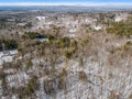 Aerial of a snow-covered sparse forest with naked trees in winter