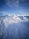 Aerial of snowy mountain slopes full of powder for freeride at ski resort on winter sunrise. Mountains range of Royalty Free Stock Photo