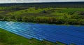 Aerial solar power farm. Drone view blue photovoltaic solar panel rows.