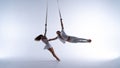 Aerial straps duo wearing white costume on white background doing performance. Concept of desire, attraction and