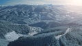 Aerial sunrise over snow mountain ranges. Winter nobody nature landscape. Spruce forest at mount Royalty Free Stock Photo