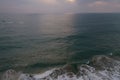 Aerial sunset drone bird view shot of the sea surface with turquoise blue water, large white waves and foam forming beautiful Royalty Free Stock Photo