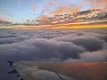 Aerial Sunset Glow Over Clouds with Airplane Wing