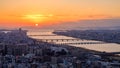 Aerial sunset view of Osaka skyline with the river, round sun, and golden sky as seen from Umeda Sky Building