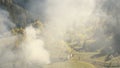 Aerial of thick smoke at mountain. Fir, leafy forest in smoky fog. Autumn nobody nature landscape Royalty Free Stock Photo