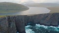 AERIAL: Tiny tourists watching the majestic rocky landscape and the rough seas.