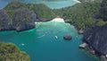 AERIAL: Tiny wooden boats and yachts sailing under impressive rocky cliffs.