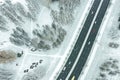 Aerial top down image of city suburb area with trees under snow and road