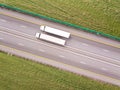 Aerial top down shot of highway with truck trailer and the meadow grass on both side of the road. Royalty Free Stock Photo