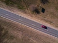 Aerial top down shot of red car on the road.