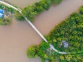 Aerial top down view bridge over muddy water canal in the Mekong River Delta region, Ben Tre, South Vietnam. Tropical islands lush