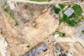 Aerial top down view of an excavator and dump trucks working on construction site Royalty Free Stock Photo