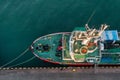 Aerial top down view of fishing boat moored in the port. Small fishing trawler ship is moored to the pier Royalty Free Stock Photo