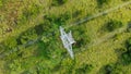 Aerial top down view high voltage steel power pylons in green field countryside. Flight over power transmission lines Royalty Free Stock Photo