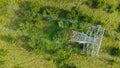 Aerial top down view high voltage steel power pylons in green field countryside. Flight over power transmission lines Royalty Free Stock Photo