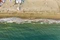 Aerial top down view of Italian resort beach with sand and foaming sea waves at sunset. Ostia Lido near Rome, Italy