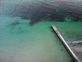 Aerial top down view of old concrete pier or breakwater with emerald sea water Royalty Free Stock Photo