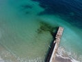 Aerial top down view of old concrete pier or breakwater with emerald sea water Royalty Free Stock Photo