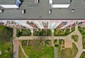 Aerial top down view on rooftop of block flat building with yard, pavements, gardens, multiple windows and balcony Royalty Free Stock Photo